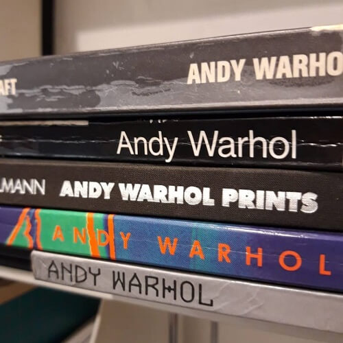 Diverse Bücher über Andy Warhol auf einem Stapel.